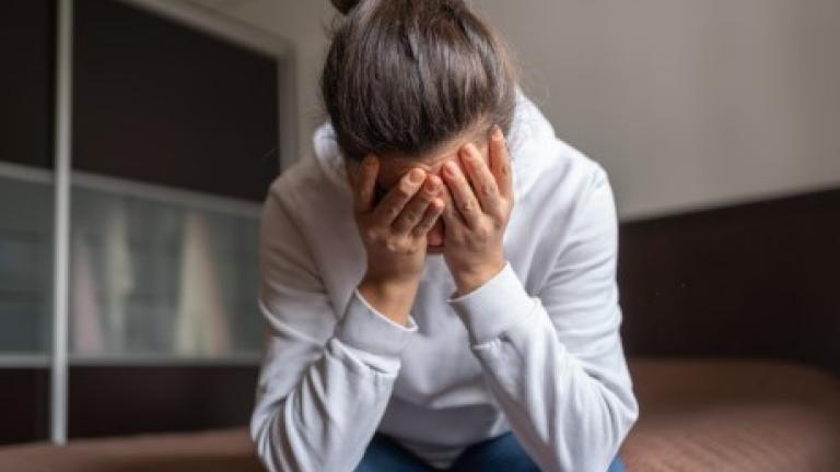 A woman holds her head in her hands
