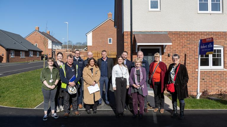 People line up for a photo to celebrate the new homes