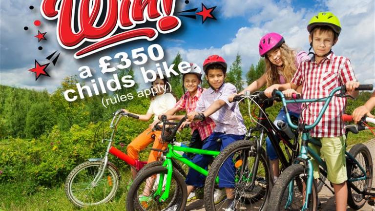 Five children smiling on bikes