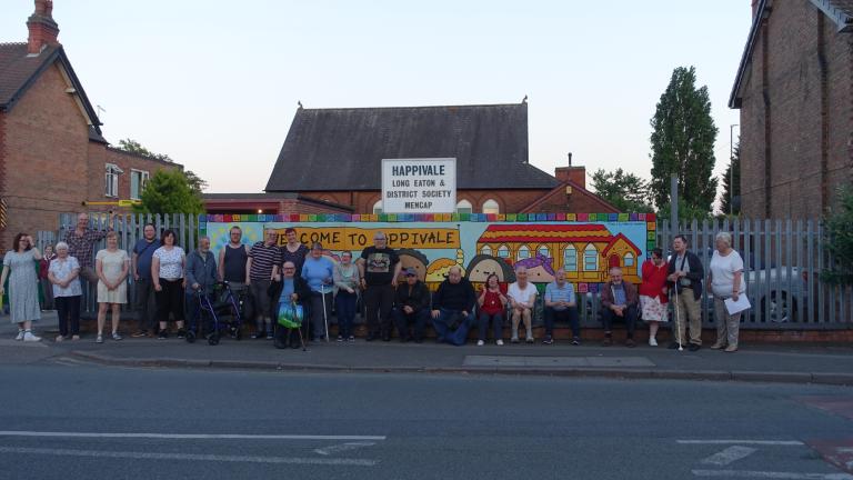 A group photo of volunteers and members in front of Happivale Social Club