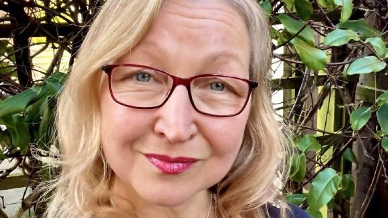 Nikki Hall, lady with blonde hair and glasses smiles