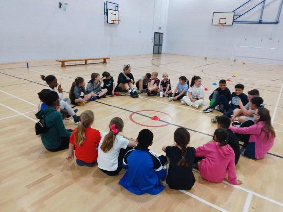 children sat in a sports hall