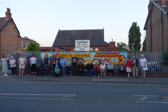 A group photo of volunteers and members in front of Happivale Social Club