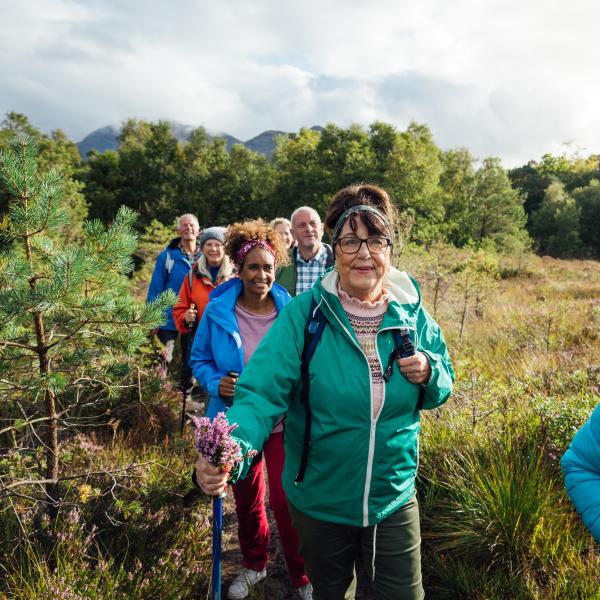 People walking in a line in the countryside, wearing walking gear